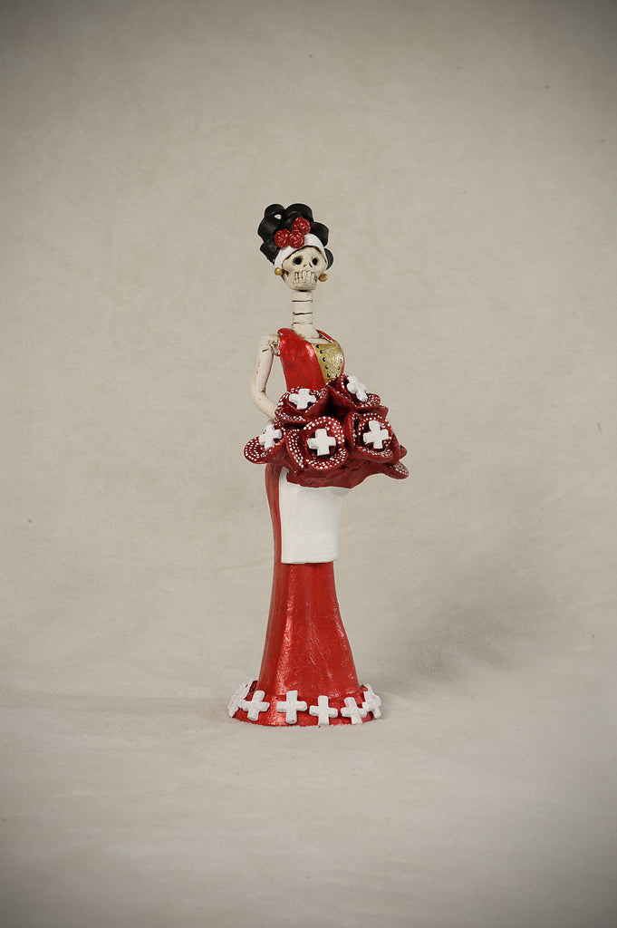  Catrina Mini Miss Switzerland is stunning like her big sister.   This beautiful miss is wearing a sleek body-contouring red gown with a white apron. To complement her look, we gave her a beautiful red flower bouquet with the symbol of her flag and a headpiece that beautifully matches her bouquet.  She will make a great addition to your Catrina collection!