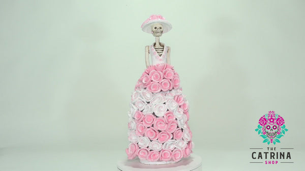 Catrina Rosamaria is part of our Roses Collection.  Rosamaria is wearing a ball gown covered in baby pink and white roses. She is wearing a stunning Victorian Era hat with pink roses and a bouquet of roses that blend in with her dress.