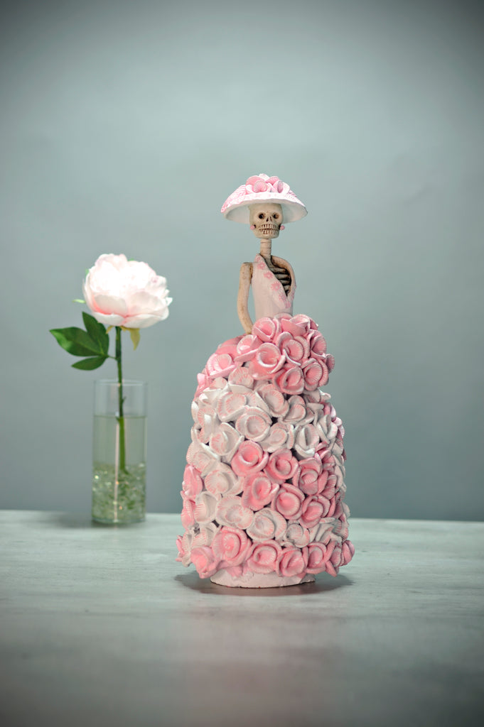 Catrina Rosamaria is part of our Roses Collection.  Rosamaria is wearing a ball gown covered in baby pink and white roses. She is wearing a stunning Victorian Era hat with pink roses and a bouquet of roses that blend in with her dress.