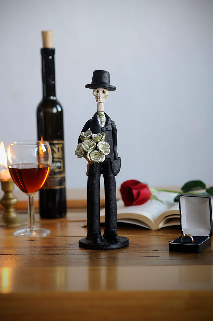 Hand-made clay figurine, Catrin Martin in gold is a small but fancy guy, he is wearing a tux with a gold tie and he is holding a gold rose bouquet. He is the perfect partner for any small Catrina. All our Catrines and Catrinas are made in Mexico and we ship worldwide. Add a classy touch of Mexican art to your home. 