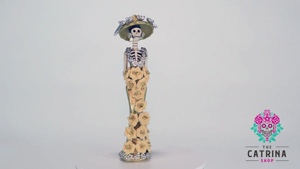Catrina Samantha is wearing a beautiful gold dress with beige poinsettias added by hand.  Her European-style hat is the same color as her dress, with silver ornaments that match her earrings and the dress's neckline.   Samantha in gold is the smallest out of the three sisters; no matter which Catrina you choose, she will make a great addition to your home.