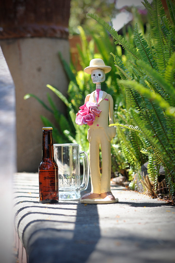 Hand-made clay figurine, Catrin Roberto in Beige and Pink is part of our Spring Collection. He is wearing a beige tux with pink accents and a rose bouquet that compliments many of our Catrinas in this collection, or any Catrina wearing pink. All our Catrines and Catrinas are made in Mexico and we ship worldwide. Add a classy touch of Mexican culture to your home. 