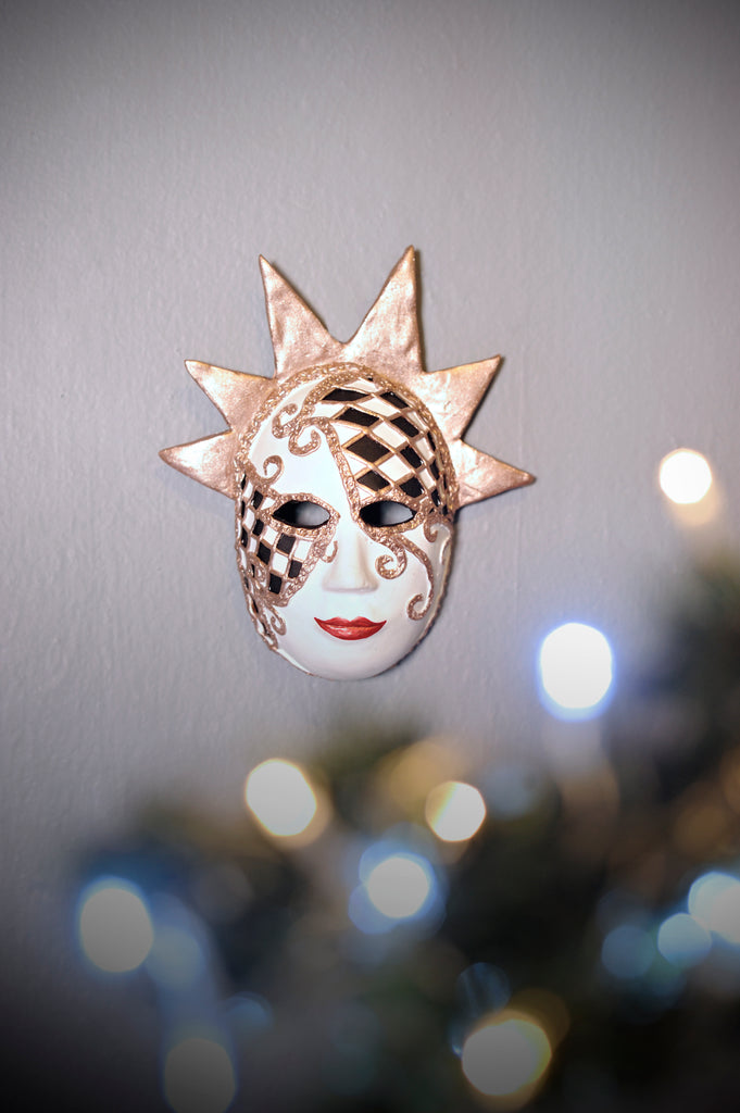 Luna is a stunning Venetian harlequin. Painted with a black and white diamond pattern with gold outlines that match her 6 point crown.   This mask goes well with all the Catrinas from our new Christmas 2021 Collection.   Luna can be hung anywhere and will surely give your home a special touch this Christmas!