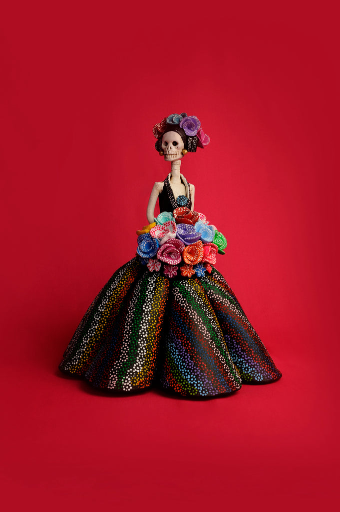 Hand-made clay figurine, made in Mexico, shipped worldwide. Anastasia is wearing a stunning dress with a plunging neckline and a ball gown skirt painted with a colorful dotted pattern. Her colorful bouquet and headpiece is also full of color. Add a classy touch of Mexican art to your home.  
