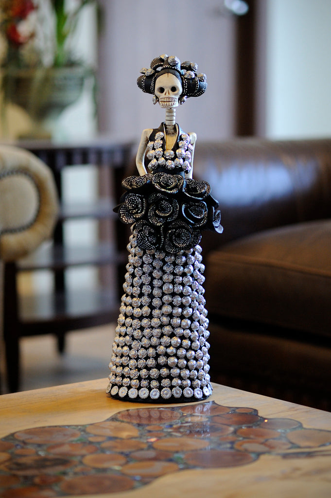 Hand-made clay figurine, Francis is wearing a dress covered in silver rosebuds and a bouquet of dotted black roses. Francis is the perfect Mother's Day gift. Add a classy touch of Mexican art to your home or office. All our Catrinas are made in Mexico and we ship worldwide. 