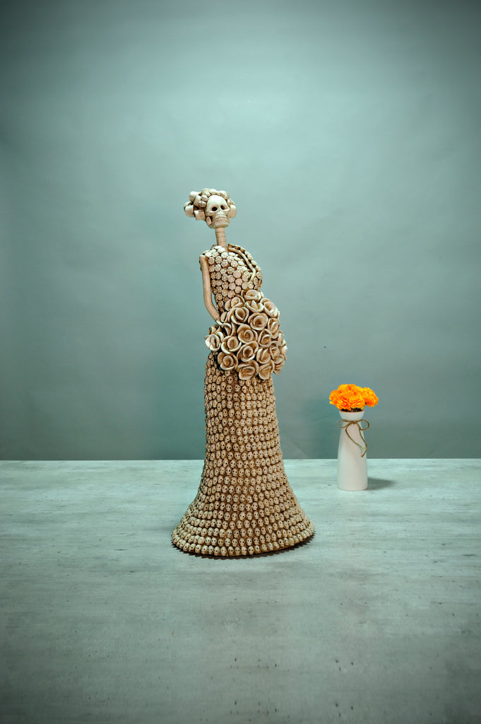 Hand-made clay figurine, Catrina Gloria has over 800 hand-made skulls carefully placed all over her skirt. Gloria is part of our Day of the Dead collection. All our Catrinas are made in Mexico and we ship worldwide. Add a classy touch of Mexican culture to your home.