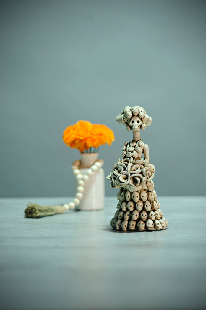 Veronica is the smallest Catrina in our Day of the Dead collection. The attention to detail and impressive workmanship are showcased with multiple skulls placed on her dress, creating an unbelievable pattern.  Veronica is a cute little thing that will add a special touch to your ofrenda!