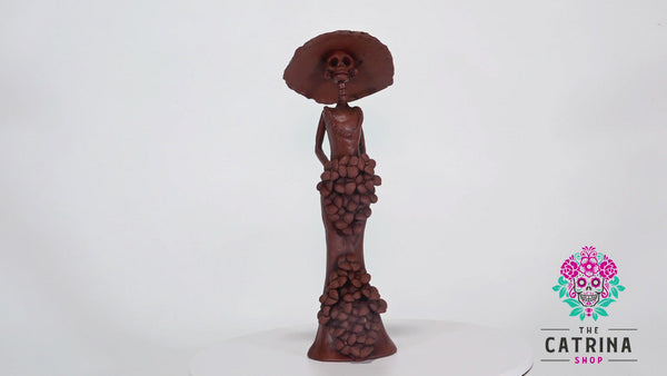 Catrina Catalina belongs to the small Catrina’s collection, but what’s wrong with being small when she is one of a kind?  Displaying a sexy mermaid dress, a creative design with pretty Forget Me Not’s on the skirt and bouquet, our artist has created Catalina, a unique piece of art, dressing her with the original Catrina Hat as Diego Rivera painted it. 
